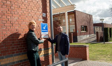 Jolande en Martijn hangen bord op 01.jpg